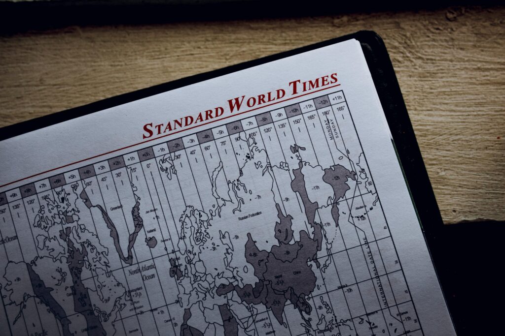 Top view of time zone illustration on page of agenda with inscription on wooden surface